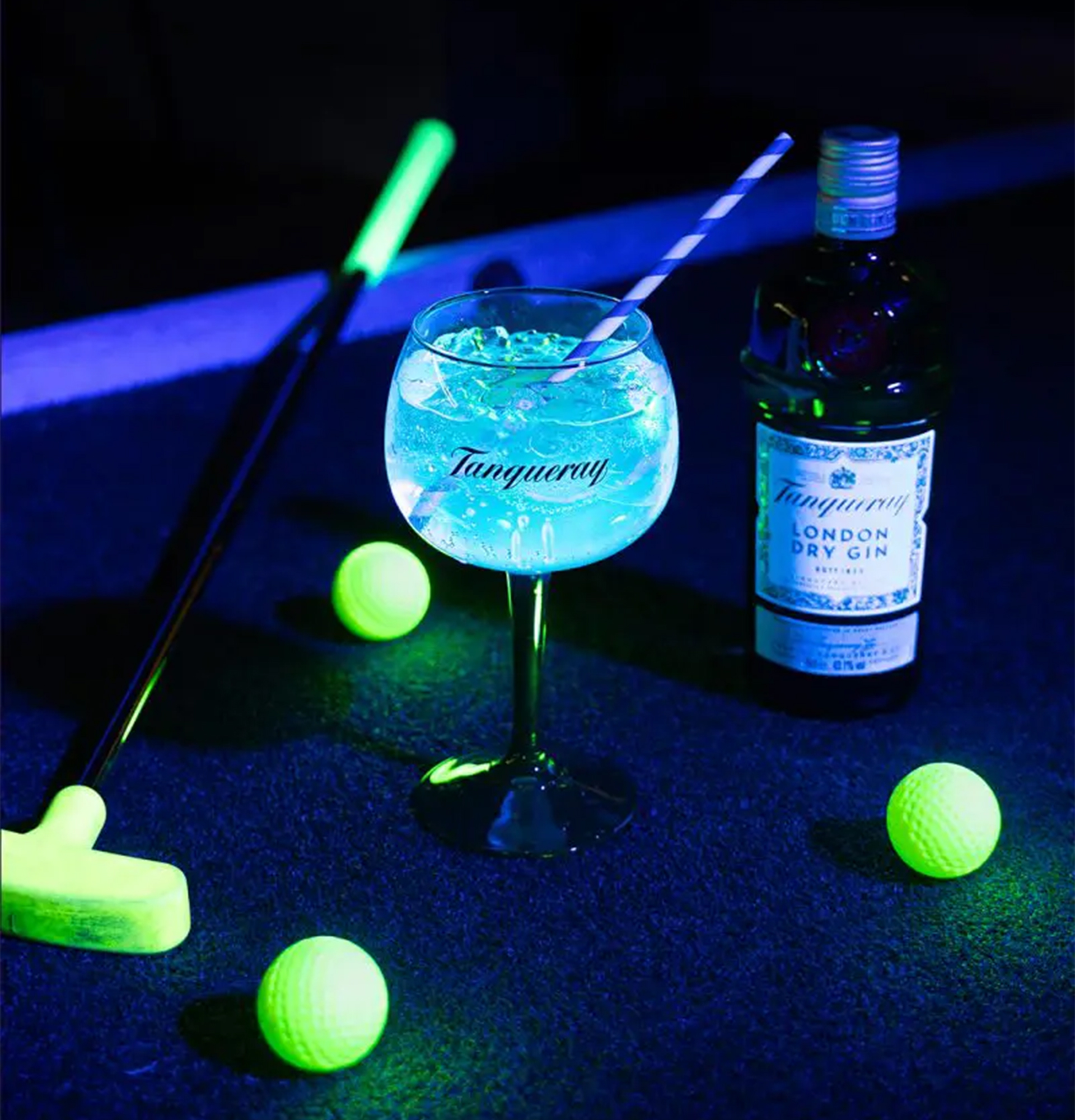Selvoplysende minigolfkølle og golfbolde til Natgolf på Camping Bar sammen med en Gin & Tonic.