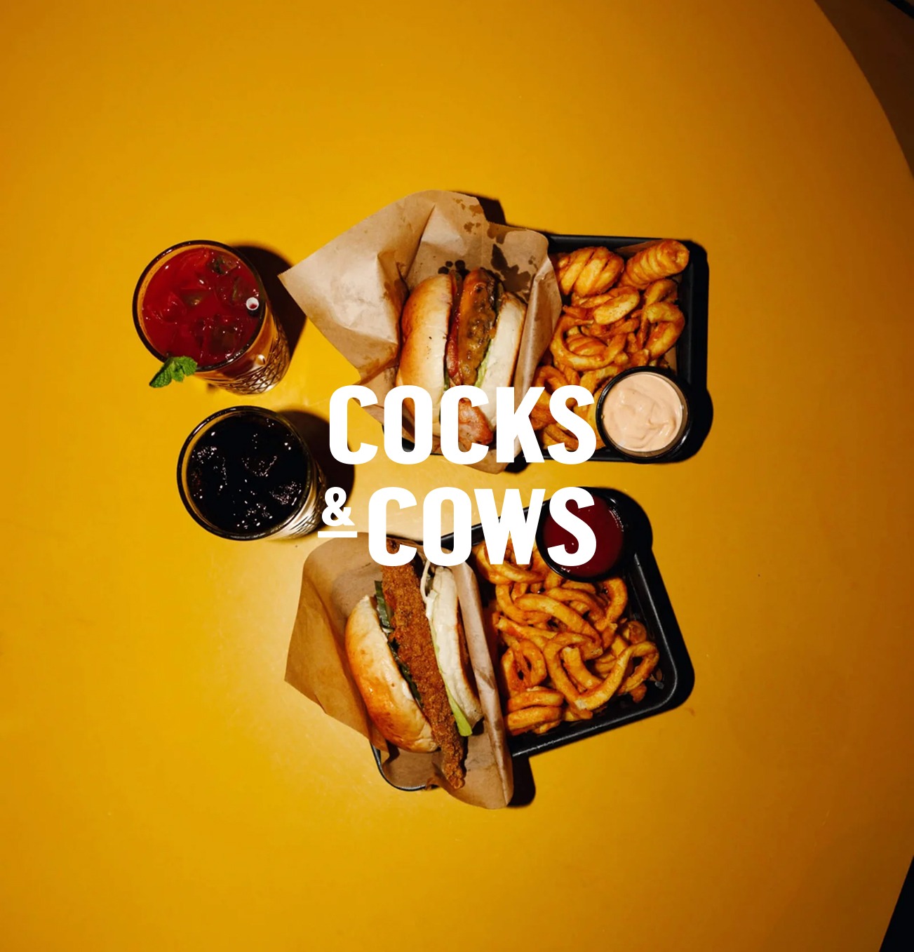 To burgere fra Camping Bar med tilhørende pomfritter, dip og drinks.